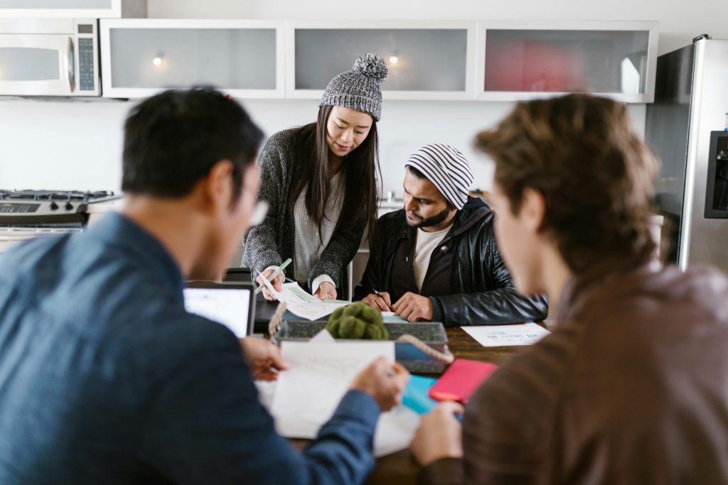 Un groupe dynamique de jeunes entrepreneurs discutent de planification patrimoniale dans un espace de bureau bien éclairé.
