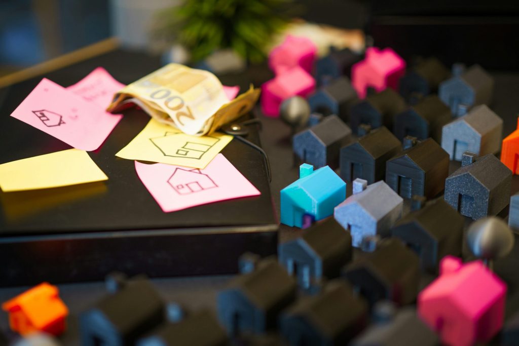 Maisons miniatures avec des billets en euros et des post-it.